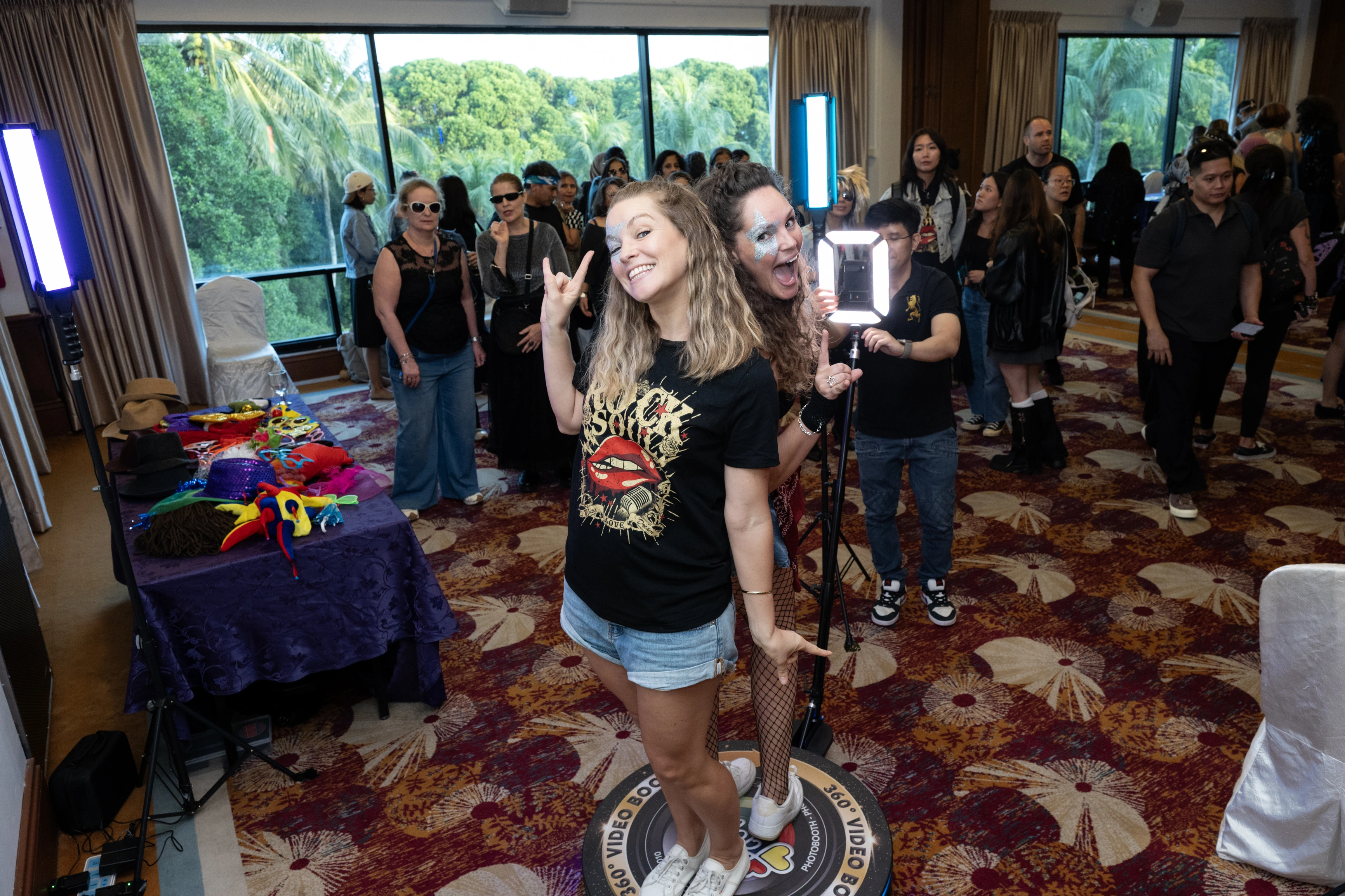 Guests posing playfully on a 360 degree video booth platform