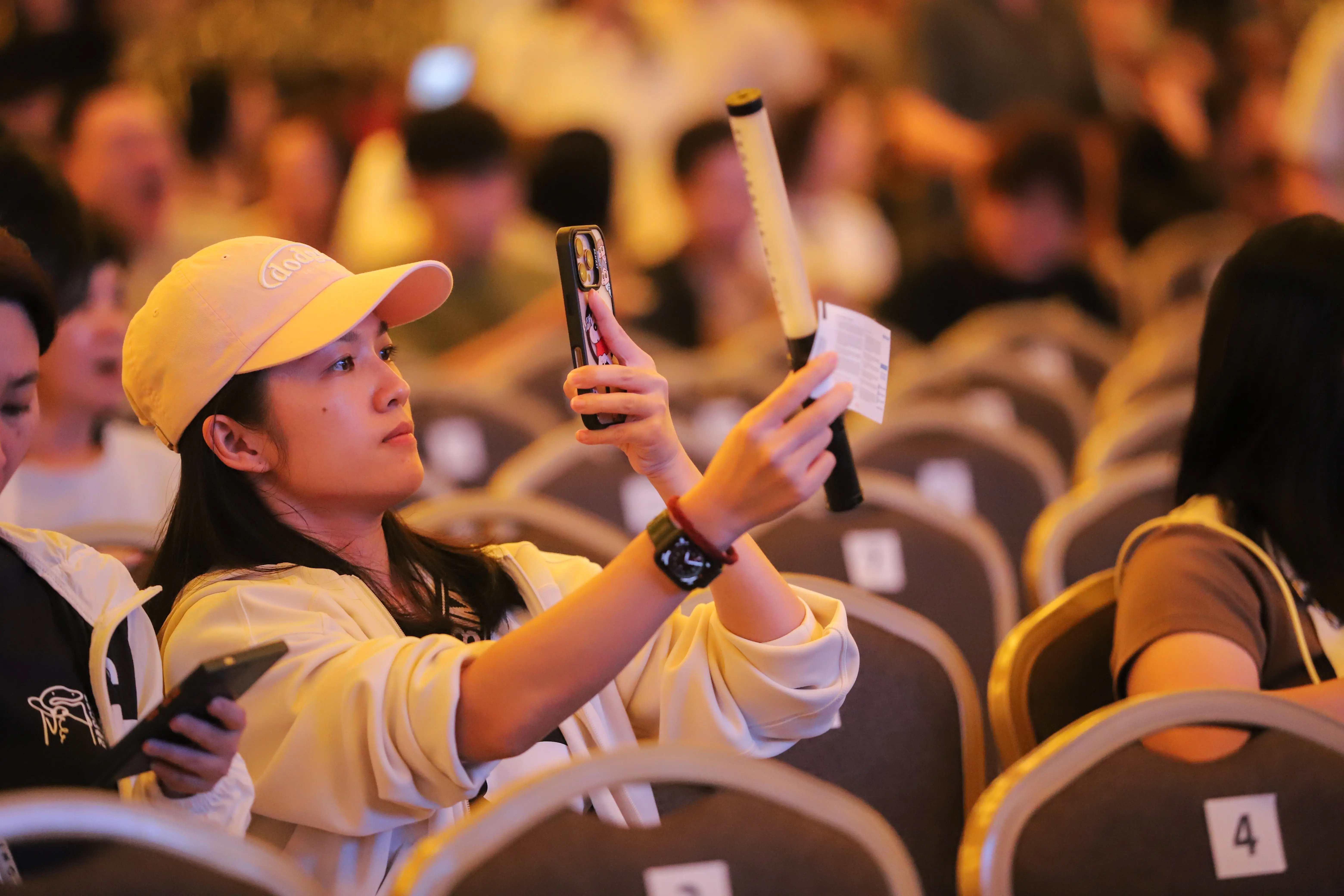 Event guest capturing live stage moment on mobile phone screen