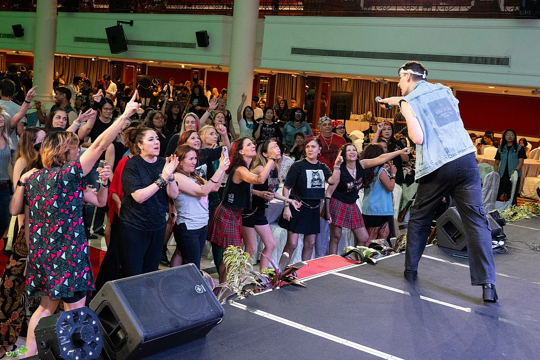 Active crowd participating and cheering during a live stage event performance
