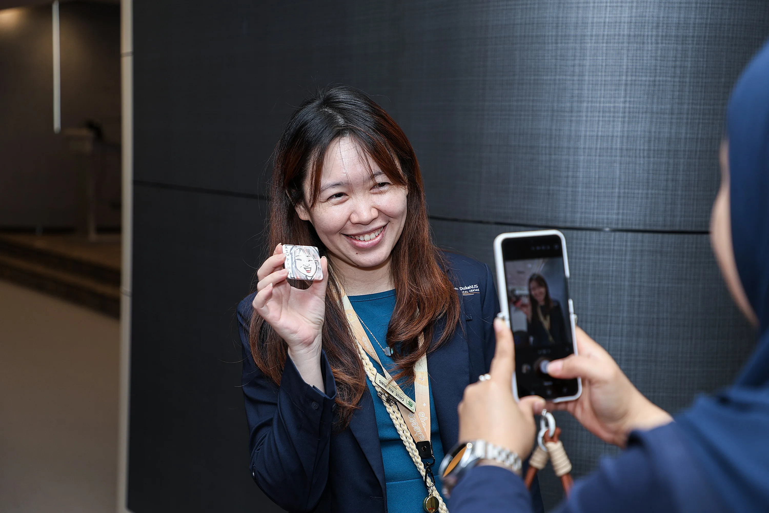 A smiling attendee holding up a personalized event souvenir print