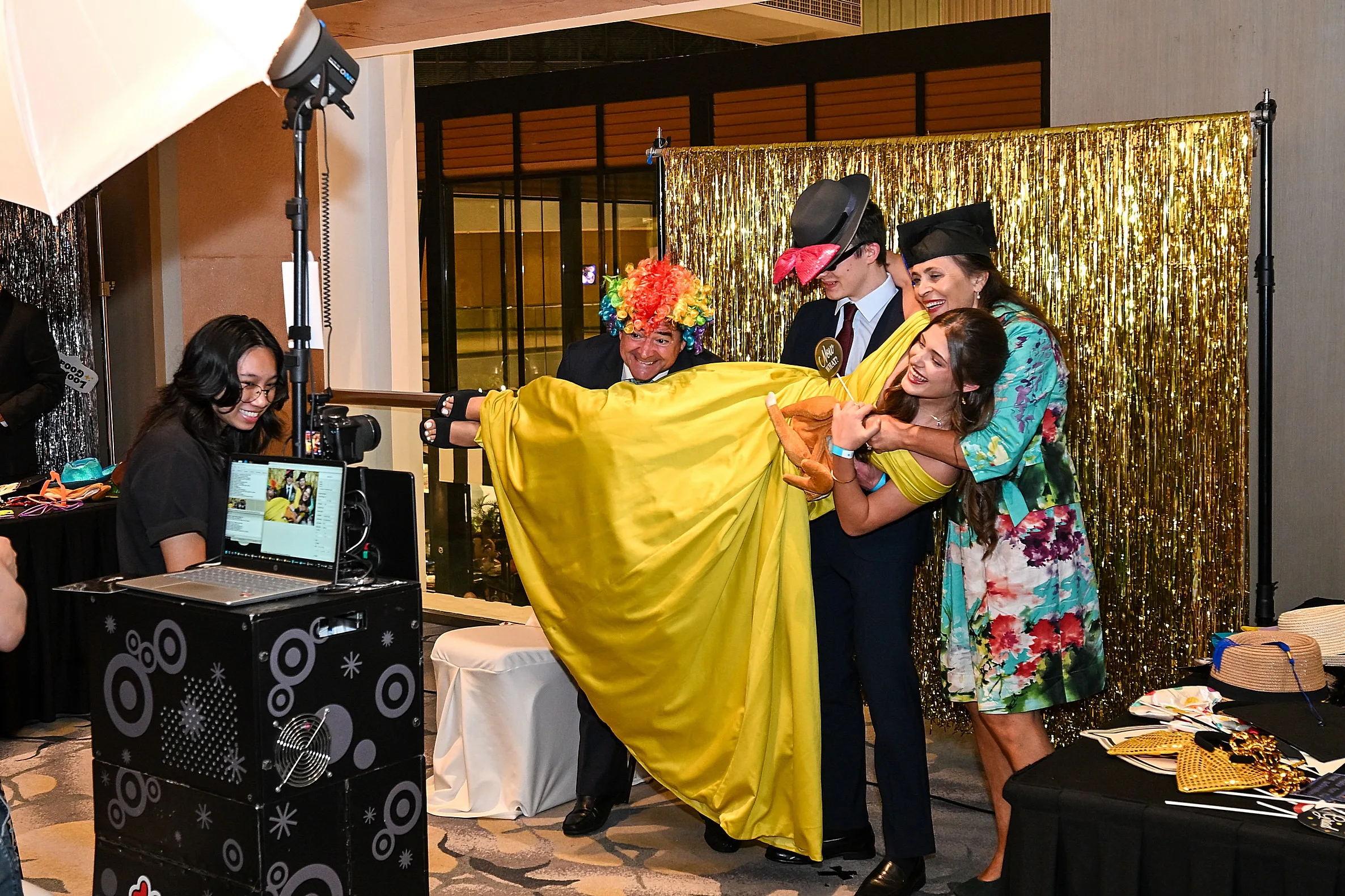 Group of guests having fun posing with funny props at an indoor photo booth setup