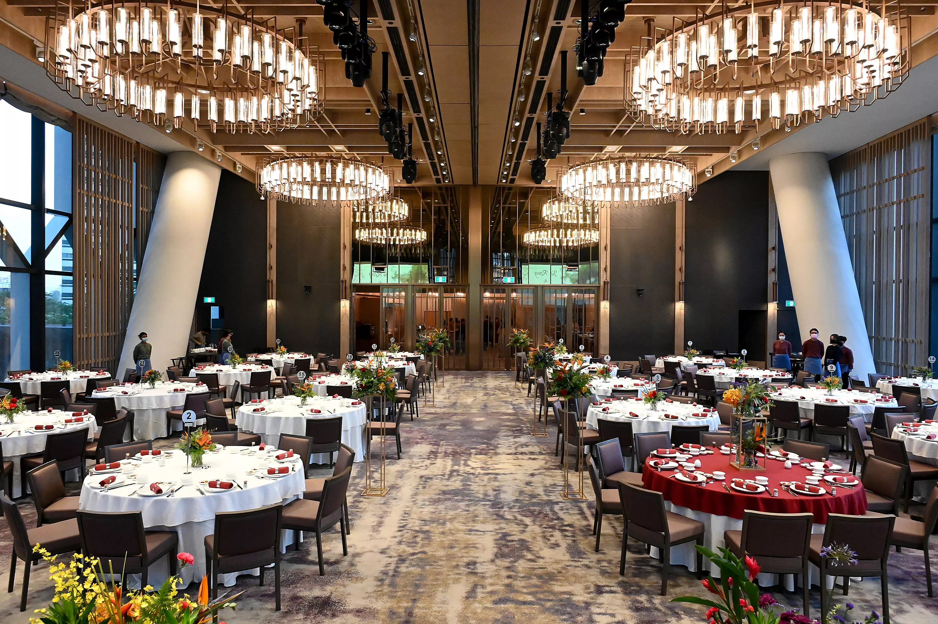 Grand hotel ballroom setup with hanging chandeliers and round tables