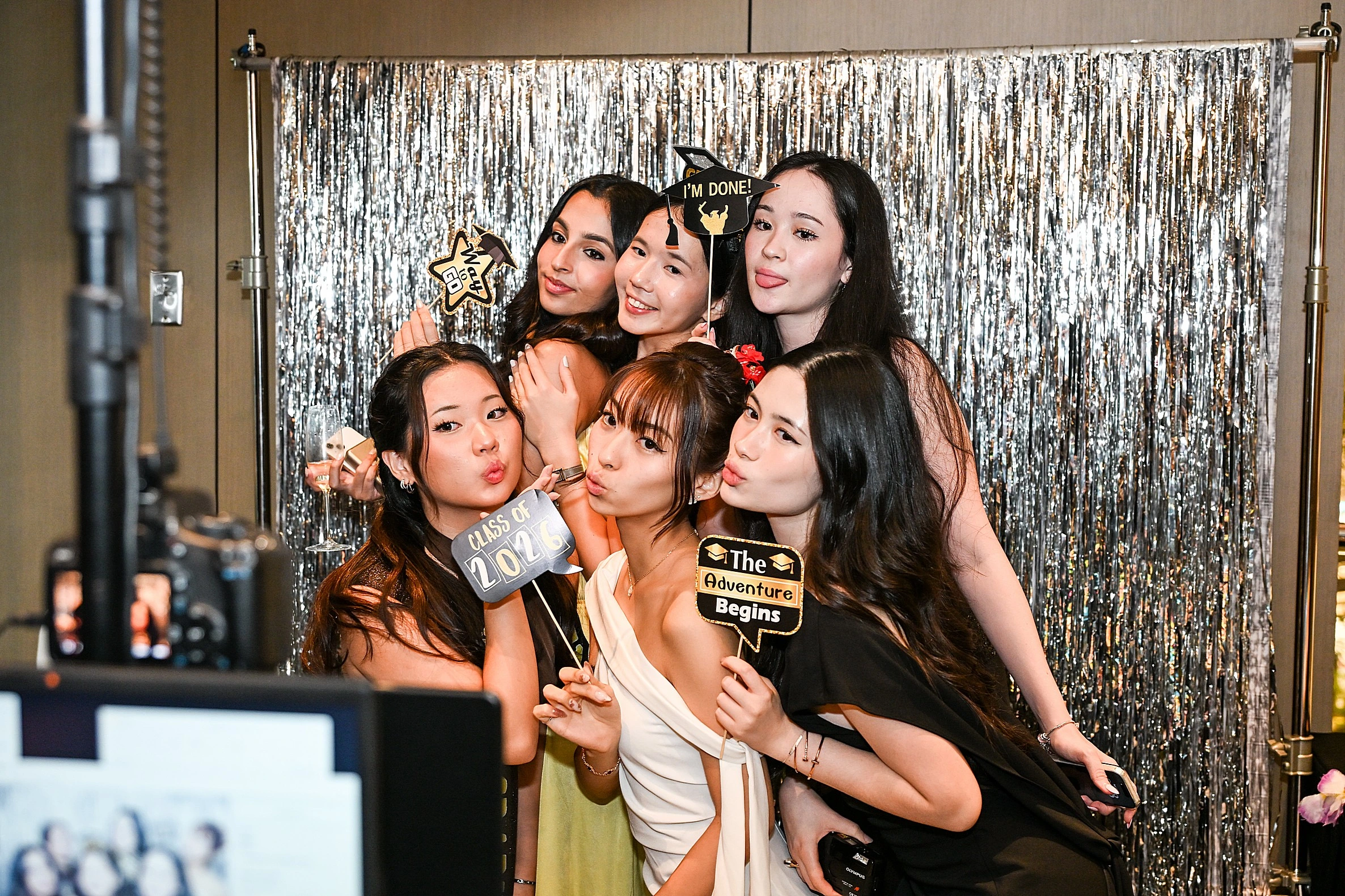 Guests posing with fun props at a Fabfoto photo booth setup in Singapore