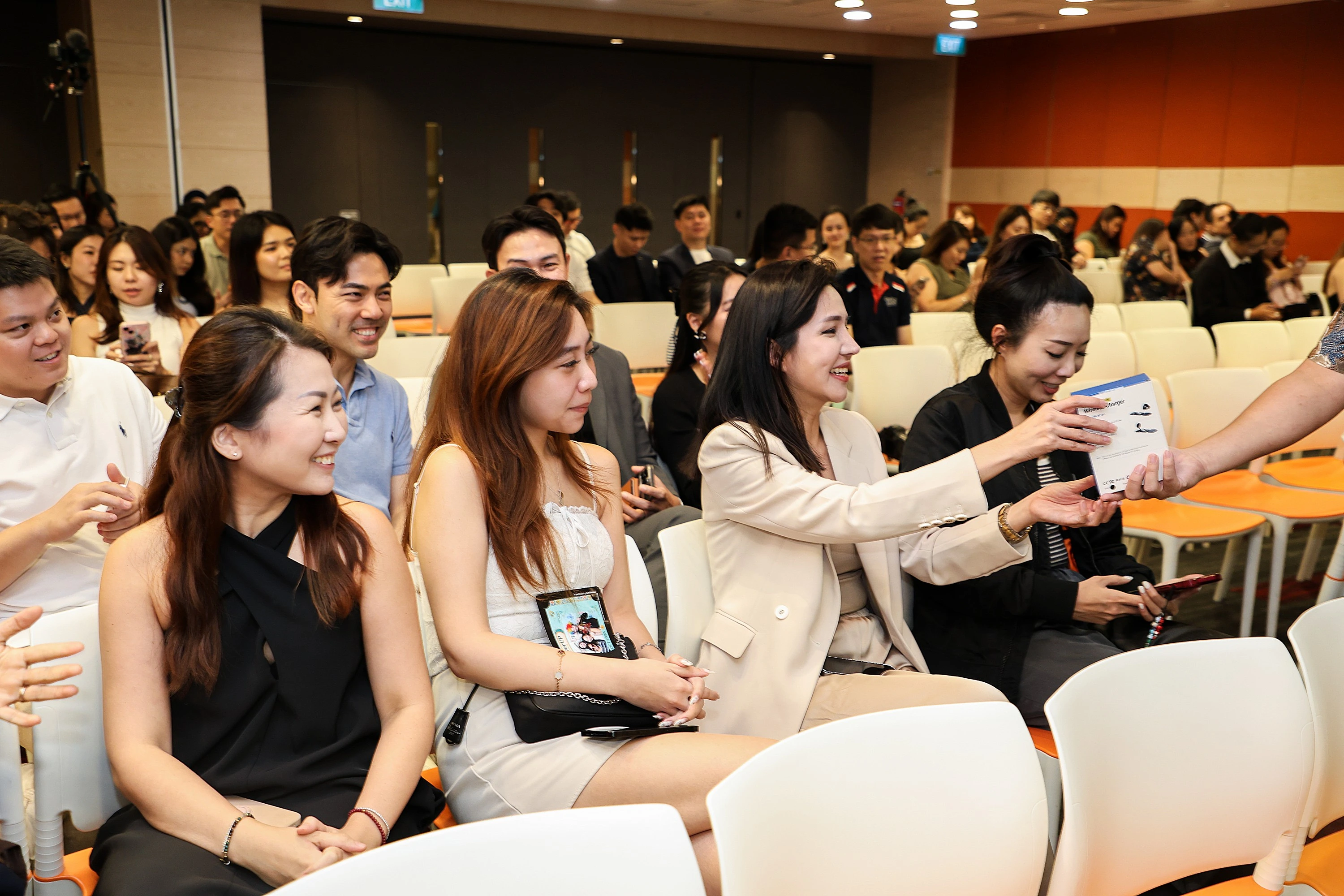 An attendee receiving a prize item at a Singapore corporate seminar