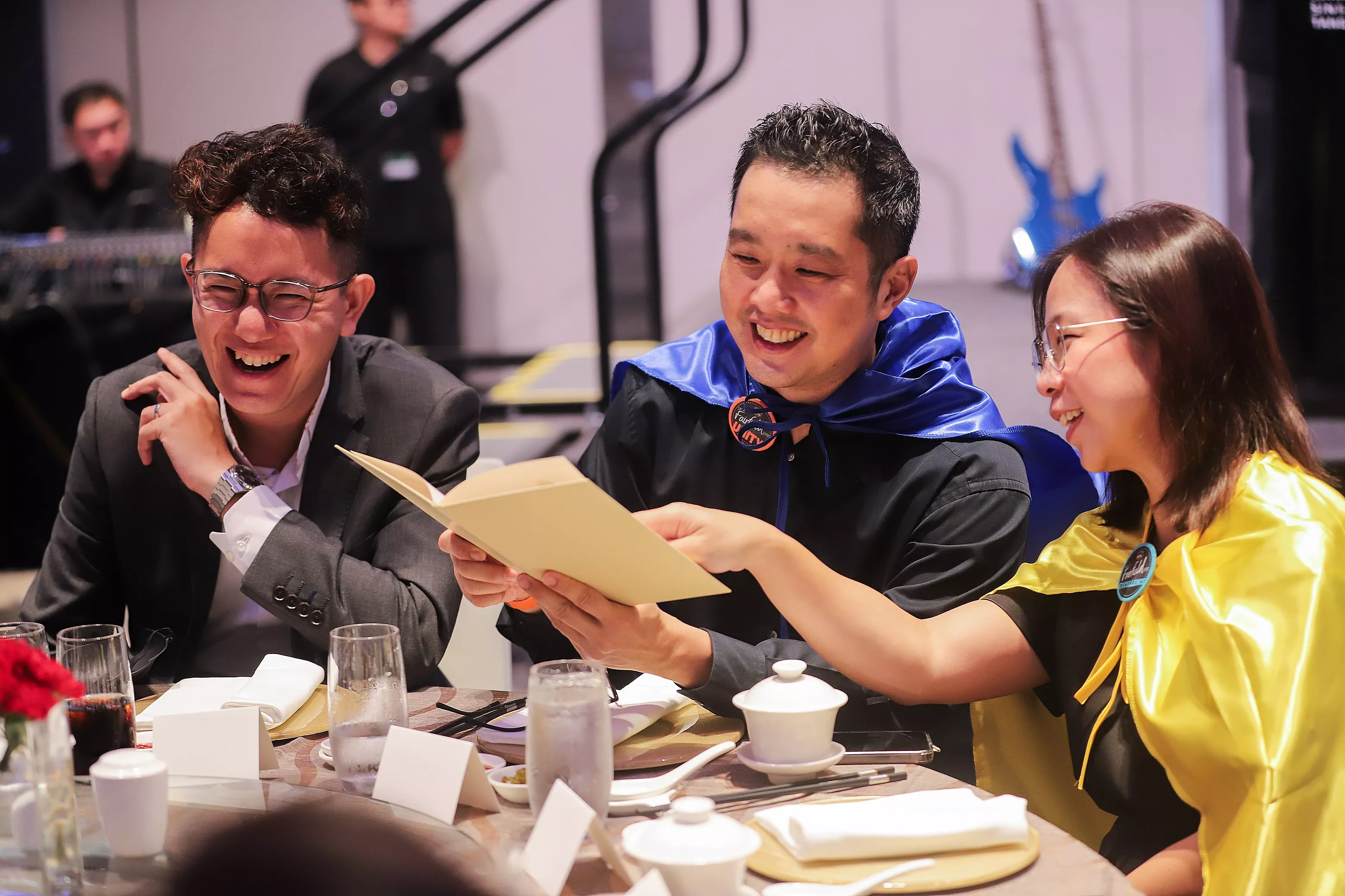 Table guests engaging in a shared activity card game at a Singapore banquet table