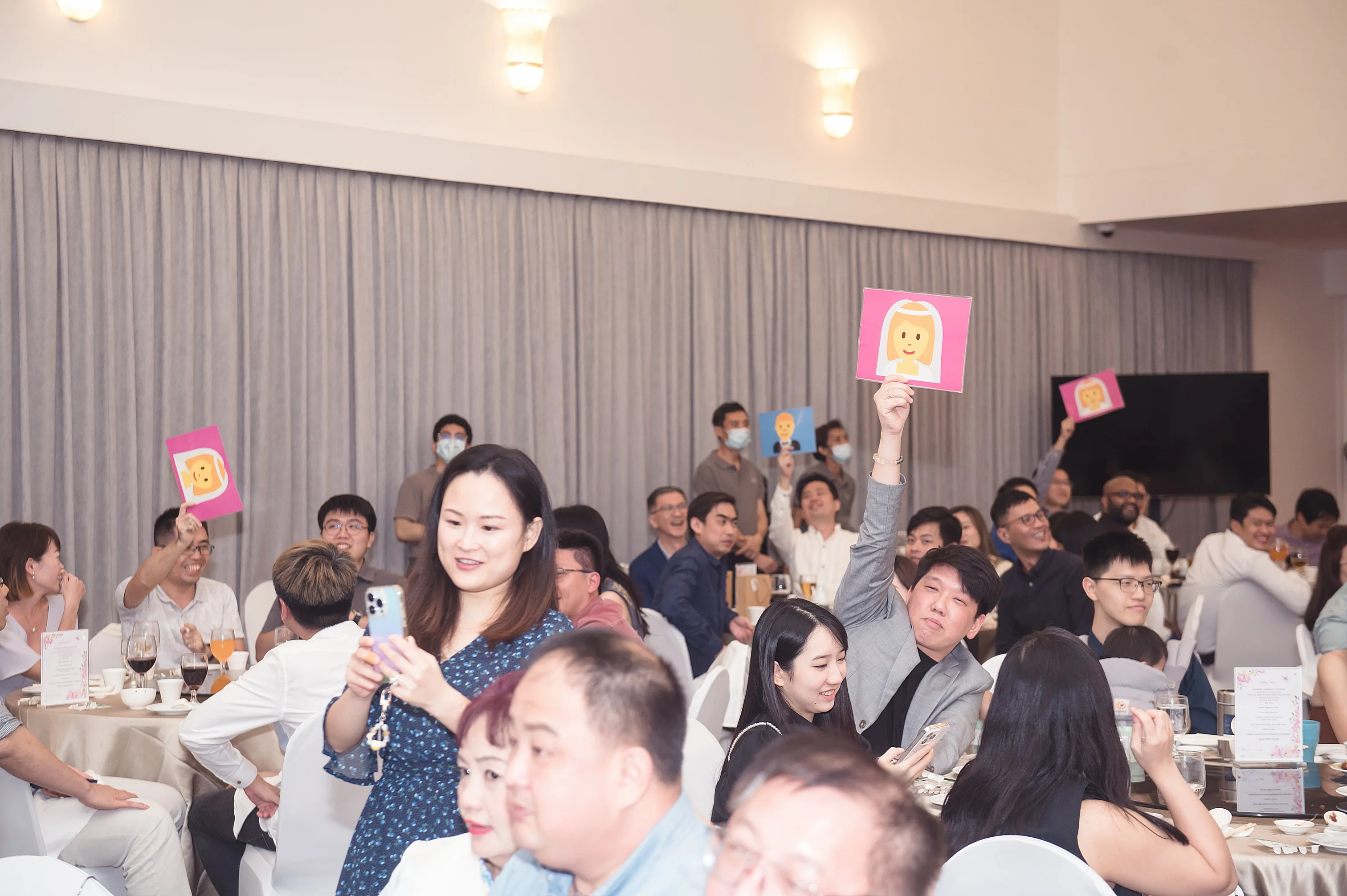 Guests participating in a voting challenge with pink and blue paddle cards