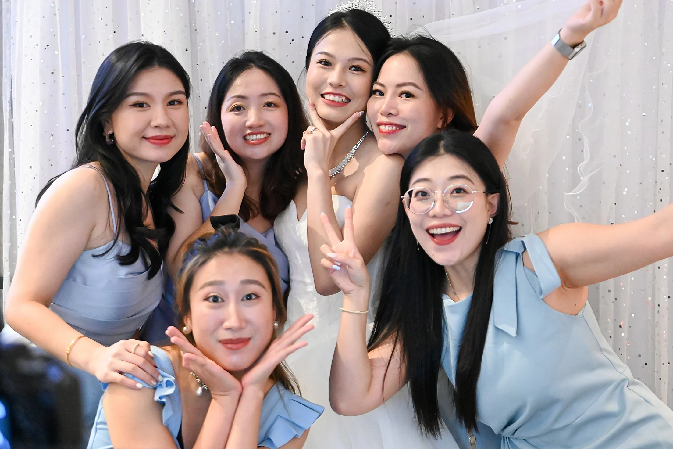 Bride and her bridesmaids posing cheerfully at a Fabfoto wedding photo booth setup